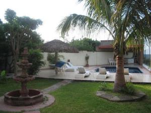 podwórko z palmą i basenem w obiekcie Casa Circuito del Lago w mieście Tequesquitengo
