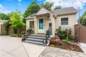 une maison avec une terrasse couverte et des escaliers en face de celle-ci dans l'établissement North End Cottage, à Boise