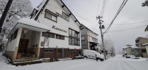 a building with snow on the side of it at KONAYUKI in Myoko