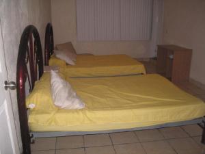 3 łóżka w pokoju z żółtą pościelą w obiekcie Casa Circuito del Lago w mieście Tequesquitengo