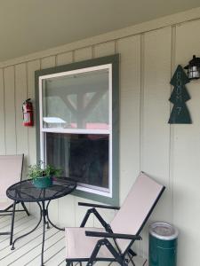 a table and chairs on a porch with a window at Elk Horn Lodge in Cooke City