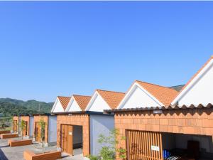 a row of houses with roofs at Awajishima Hotel Lodge GREEN COZY in Minamiawaji