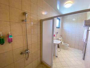 W łazience znajduje się prysznic, umywalka i toaleta. w obiekcie Lei Mi Er Hua Yuan Min Su w mieście Pinghe