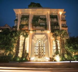 un edificio bianco con luci accese di notte di HARI Residence & Spa a Siem Reap