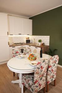 cocina con mesa blanca y sillas en Apartments Paola en Rovinj