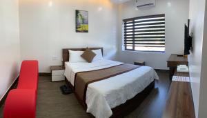 ein Schlafzimmer mit einem großen Bett und einem roten Stuhl in der Unterkunft Win Win Hotel - Khách Sạn Hải Phòng in Haiphong