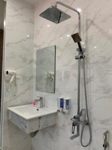 a white bathroom with a sink and a shower at Win Win Hotel - Khách Sạn Hải Phòng in Hai Phong