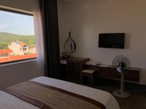 a bedroom with a bed and a window with a fan at Win Win Hotel - Khách Sạn Hải Phòng in Hai Phong +57 photos