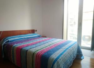Ce lit se trouve dans une chambre dotée d'une couverture colorée. dans l'établissement Os limoeiros do cura, à Foz