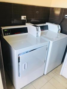 シドニーにあるWestside Motor Innの白い洗濯機と乾燥機が隣接しています。