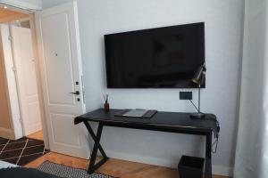 a black desk with a television on a wall at The Herbert Tel Aviv in Tel Aviv