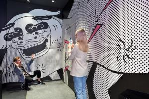 una mujer parada frente a una pared con una pintura en HOTEL TAVINOS Asakusa, en Tokio