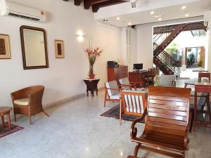 a lobby with chairs and tables and a mirror at Heeren Straits Hotel in Malacca