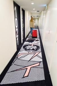 una mujer caminando por un pasillo con una maleta roja en HOTEL TAVINOS Asakusa, en Tokio 37 fotos más