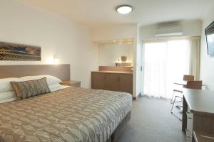 a hotel room with a bed and a desk and a kitchen at Loxton Community Hotel Motel in Loxton