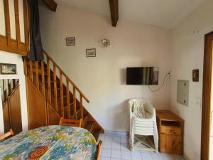 une chambre avec un lit et une télévision au mur dans l'établissement Pavillon proche plage ~ Hameau du Soleil, à Port-la-Nouvelle