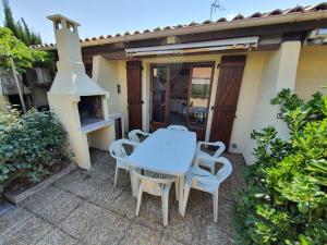 une table et des chaises devant une maison dans l'établissement Pavillon proche plage ~ Hameau du Soleil, à Port-la-Nouvelle 26 autres photos