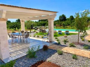 a patio with a table and chairs under a pergola at Trulli Paradise Alberobello in Alberobello