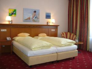 1 dormitorio con 1 cama con cabecero de madera en Hotel Alexandra, en Wels
