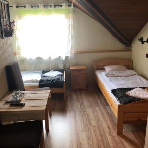 a room with two beds and a table and a window at U Pauli i Eryka in Łeba +21 photos