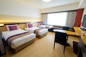 東京にあるホテルメトロポリタン エドモント 東京のベッド2台とデスクが備わるホテルルームです。