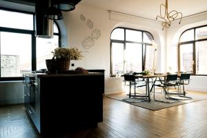 uma cozinha com mesa, cadeiras e janelas em Gran loft en los pinares de Covaleda, Soria em Covaleda