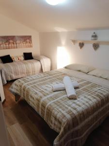 1 dormitorio con 2 camas y toallas. en La Casetta in Montagna, en Pietracamela