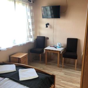 a bedroom with a bed and two chairs and a table at U Pauli i Eryka in Łeba