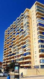 un grand immeuble d'appartements avec un panneau en face de celui-ci dans l'établissement Bellreguart 1a línea de Playa - Edificio Mirador, à Bellreguart