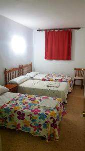 - 3 lits dans une chambre avec rideau rouge dans l'établissement Bellreguart 1a línea de Playa - Edificio Mirador, à Bellreguart