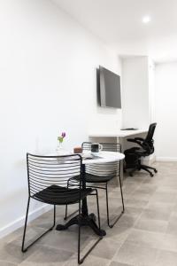 a room with two chairs and a table and a desk at Fountain View Motel in Dubbo