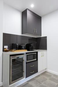 a kitchen with black and white cabinets and appliances at Fountain View Motel in Dubbo