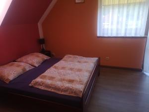 a bedroom with a bed and a window in a room at Zajazd Nad Rzeczką in Miłków