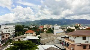 a city with buildings and mountains in the background at Chor Chang House in Chiang Mai