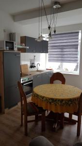 una cocina con mesa y algunas sillas y una mesa y una cocina con en Apartment Halmis FeWo WR, en Wernigerode