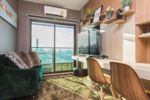 a room with a desk and chairs and a window at Lumpini Suite Phetchaburi-Makkasan in Bangkok