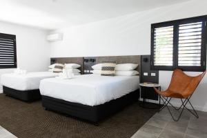 a bedroom with two beds and a chair at Fountain View Motel in Dubbo