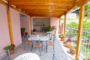 a patio with tables and chairs on a balcony at Angela in Loutra Edipsou