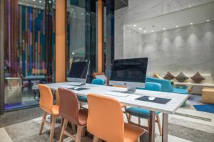 Holiday Inn Express Qingdao Chengyang Central by IHG في تشينغداو: طاولة عليها جهازين كمبيوتر مع الكراسي
