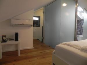 a bedroom with a bed and a desk and a window at Milchhaus Zimmer - Tiny House in Balingen