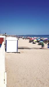 - une plage avec beaucoup de personnes et de parasols dans l'établissement Bellreguart 1a línea de Playa - Edificio Mirador, à Bellreguart