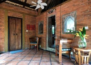 JasriにあるHIDDEN HEAVEN Rumah Barongのポーチ(椅子、テーブル付)、天井ファン