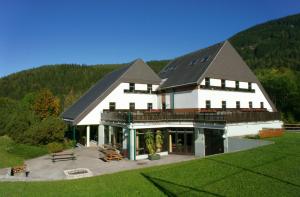 a large white building with a black roof at Junges Hotel Annaberg in Annaberg