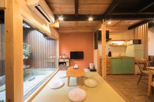 a room with a tub and a table and a kitchen at Nishodo Machiya HIKARU OIKE in Kyoto