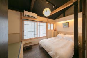 a bedroom with a bed and a large window at Nishodo Machiya HIKARU OIKE in Kyoto