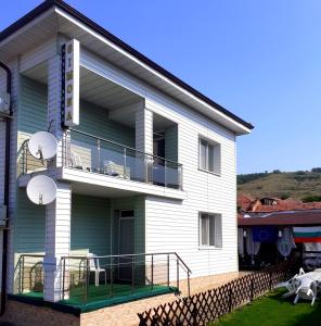 a large white building with a balcony and a patio at Guest Rooms Simona in Opanets