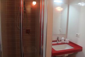y baño con lavabo rojo y ducha. en Blue Sea Rooms Apartment Cagliari, en Cagliari