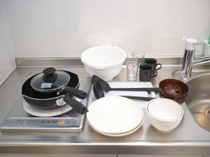 a kitchen counter with plates and bowls on a stove at Mango Resort Okinawa Chatan in Chatan