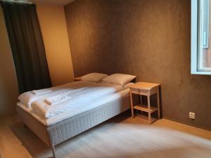 a small bed in a room with a table at Nygårdsgaten apartments in Bergen