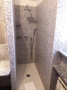 bagno con doccia e piastrelle grigie di Hotel Vittoriano a Torino